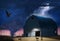 A tornado drops from a lightning storm and tosses debris and heads for a vintage wooden barn as animals and farmer flee