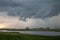 A tornado forms beneath a supercell storm with funnel cloud extending towards the ground.