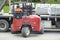 Toronto, Canada - April 28, 2020: Workman Driving a Red Forklift to Move a Pile of Concrete Patio Stones on a Suburban Street  3