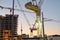 Toronto construction site with cranes and CN Tower at sunrise