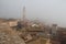 Torre del Mangia in Piazza del Campo and tupical ref roofs of Siena in mist. Tuscany, Italy.