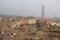 Torre del Mangia in Piazza del Campo and tupical ref roofs of Siena in the thick fog. Tuscany, Italy.