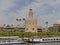 Torre del Oro, historical watchtower along Guadalquivir river with tourist boat  in Sevilla.