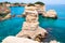 Torre Sant Andrea beach with its soft calcareous rocks and cliffs, sea stacks, small coves and the jagged coast landscape. Crystal