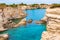 Torre Sant Andrea beach with its soft calcareous rocks and cliffs, sea stacks, small coves and the jagged coast landscape. Crystal