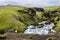 Torrent in the middle of a meadow in iceland with a sheep