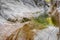 Torrent of water falling on the polished rocks of the river bed in a mountain