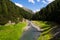 Torrente vallaccia flows into lake Lago di Livigno reservoir, Italy