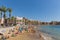 Torrevieja Spain with people sunbathing and swimming on Playa Cura beach in the October sun