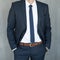 Torso of a businessman standing with hands clenched in middle position in a classic navy blue suit.