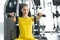 Torso portrait of Cheerful young adult caucasian woman working out on exercise machine inside gym