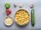 Tortellini bowl with zucchini, mushrooms and vegetarian cooking ingredients on kitchen table background with cutting board , top v