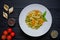 Tortellini cooked pasta with differed kinds of pepper, allspice, red tomato and green pepper. Italian cuisine on wooden rustic ta