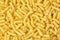 Tortiglioni italian pasta texture background, top view