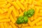 Tortiglioni Noodles background with basil leaf