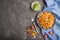 Tortiglioni semolina pasta with tomato and microgreen sprouts on a black concrete background. Top view, copy space