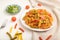 Tortiglioni semolina pasta with tomato and microgreen sprouts on a white wooden background. Side view, close up