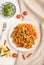 Tortiglioni semolina pasta with tomato and microgreen sprouts on a white wooden background. Top view, close up