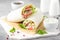 Tortilla with salmon, lettuce and cream cheese. Delicious snack wraps with fish and salad. Healthy burrito with pita bread for