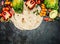 Tortillas flat and various vegetables for tacos or burrito making on rustic background, top view