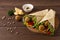 Tortillas wrapped with falafel balls and fresh vegetables, vegetarian healthy food, on a wooden background, no people,