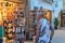Tossa de Mar, Spain, August 2018. An interesting man with tattoos examines a souvenir shop.