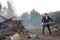 Tossing firewood in the fire. A man throws logs into the fire in nature.