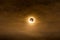 Total solar eclipse in dark red cloudy sky