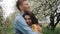 The touching couple in love cuddles and kisses against the backdrop of spring flowering trees. Close-up. The camera