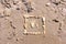 Touching picture of sea pebbles on  sandy beach. Image of a child`s and adult`s foot made of stones. Ebbles and sand in the sea.