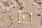 Touching picture of sea pebbles on  sandy beach. Image of a child`s and adult`s foot made of stones. Ebbles and sand in the sea.