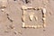 Touching picture of sea pebbles on  sandy beach. Image of a child`s and adult`s foot made of stones. Ebbles and sand in the sea.