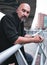 Tough Colombian guy with goatee poses under a bridge