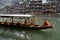 A tour boat operator sits alone in a sampan  on the Tuo Jiang River in Fengshuan Ancient City in Tibet, China