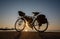 Touring bikes parked by the sea at sunset.