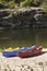 Touring canoes on river bank