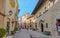 Tourism in Barceloneta - tourists & people walk down a street of small town on interior of Barcelona.