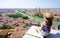 Tourism in Italy. Beautiful young woman sitting on wall enjoying stunning view of Verona, Italy