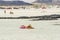 Tourism and tourists concept in summer holiday vacation - nice woman enjoying sunbath on a coloured lilo in the sea water at the