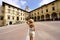 Tourism in Tuscany. Back view of young traveler woman holding hat in Piazza Grande square in the old town of Arezzo, Tuscany,
