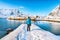 Tourist admire the view of the Sakrisoy village and snowy mountaines on background