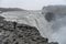 Tourist admiring view of falling water of the most powerful waterfall in Europe - Dettifoss