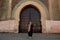 Tourist by authentic gate in Meknes, Morocco