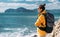 Tourist with a backpack against the sea, panorama. Portrait of a woman in tourist gear against the sea. Travel