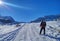 Tourist with a backpack and a karemate climbing mountains in winter