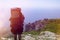 Tourist with a backpack looking from the mountains to the sea. Hiking in the mountains of Crimea. View of the forest and the city