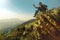 Tourist with backpack sits on top of the mountain and takes pictures of the landscape on cellphone