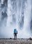 Tourist with backpack on the Skogafoss waterfall background. Travelling on Iceland. Tourist in the famouns place in Iceland.