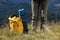 Tourist with backpack, sleeping pad and binoculars in mountains on sunny day, closeup