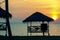 Tourist beach huts & coconut palm trees near tropical beach with golden sunset in Pohon Batu,Labuan Island,Malaysia.